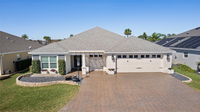 single story home featuring an attached garage, stucco siding, decorative driveway, and a front yard