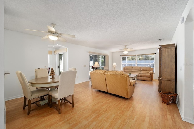 dining room featuring a textured ceiling, light hardwood / wood-style floors, and ceiling fan