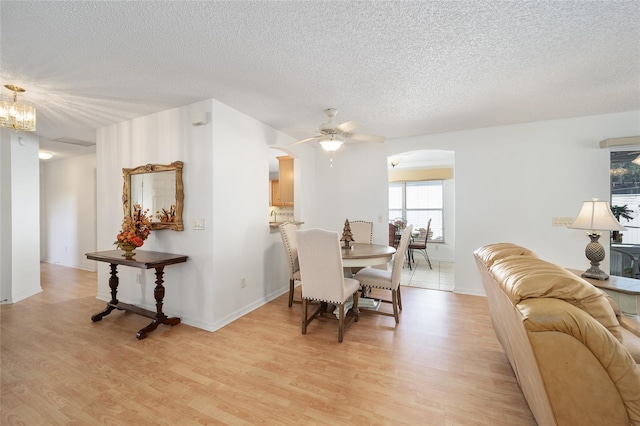 dining room with a textured ceiling, light hardwood / wood-style floors, and ceiling fan