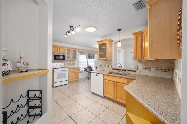 kitchen with decorative backsplash, sink, light tile patterned floors, and white appliances