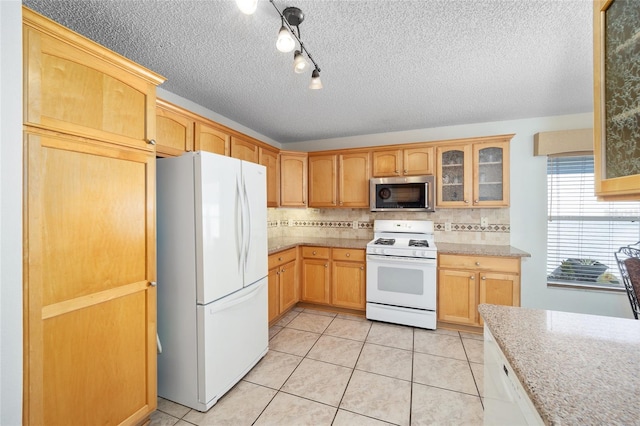 kitchen featuring a textured ceiling, white appliances, backsplash, and light tile patterned floors