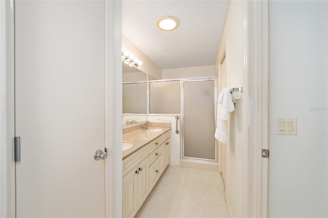 bathroom with vanity, a textured ceiling, and walk in shower