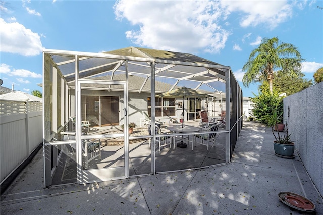 exterior space with glass enclosure and a patio area