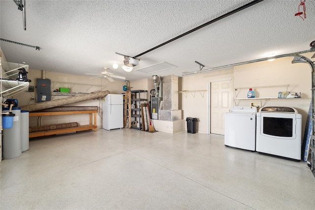 garage with a garage door opener, electric panel, ceiling fan, independent washer and dryer, and white fridge