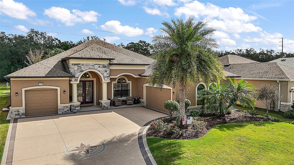 view of front facade featuring french doors, a front yard, and a garage