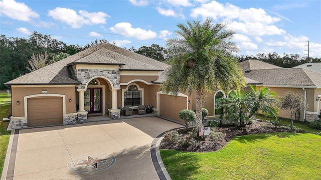 view of front facade featuring french doors, a front yard, and a garage