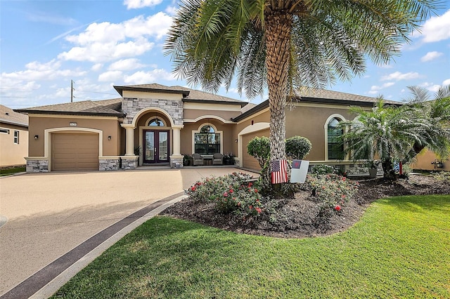 mediterranean / spanish-style home with a front lawn, a garage, and french doors