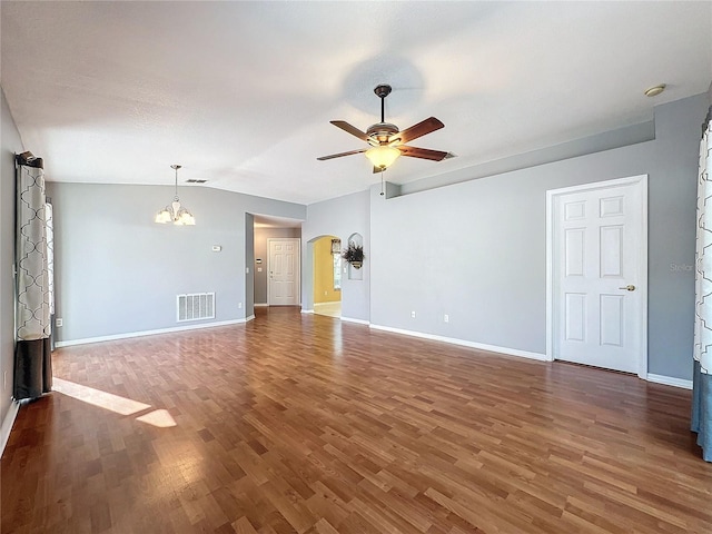 unfurnished living room featuring lofted ceiling, ceiling fan with notable chandelier, and dark hardwood / wood-style floors