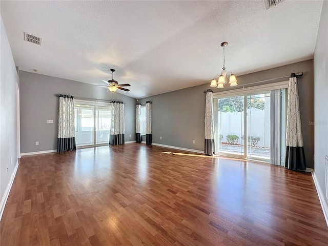 interior space featuring ceiling fan with notable chandelier, dark hardwood / wood-style flooring, and a textured ceiling