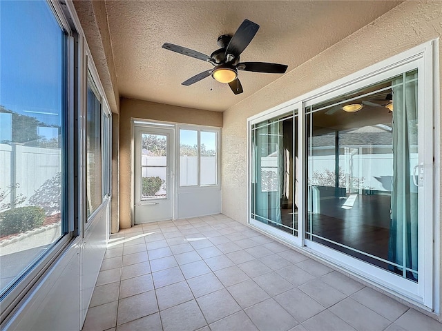 unfurnished sunroom featuring ceiling fan