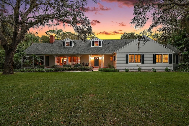 cape cod-style house featuring a lawn