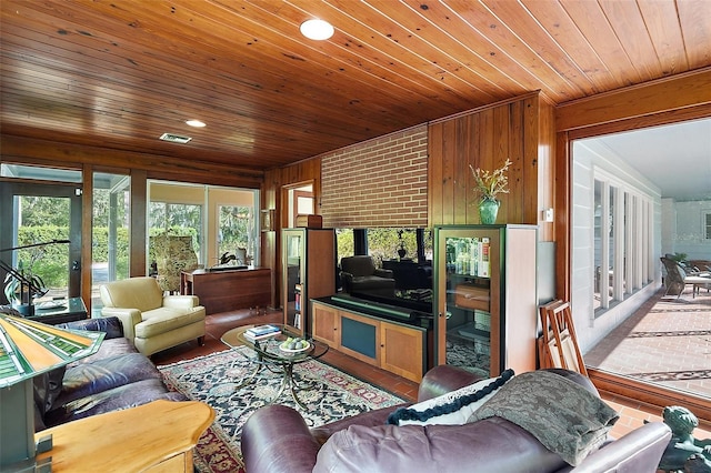 living room with wooden walls, wooden ceiling, and vaulted ceiling