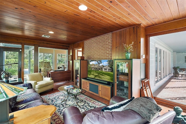 living room with lofted ceiling, wood walls, and wood ceiling