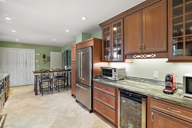 kitchen with high end fridge, wine cooler, and dark stone counters