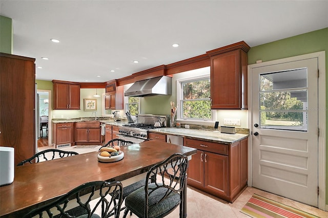 kitchen featuring appliances with stainless steel finishes, light stone counters, sink, range hood, and light tile patterned flooring