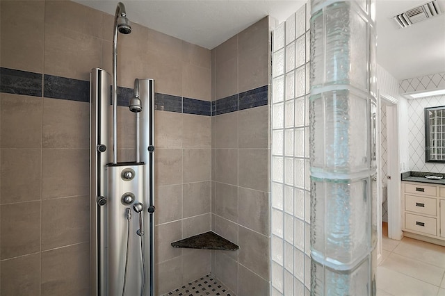 bathroom featuring tile patterned floors and a tile shower