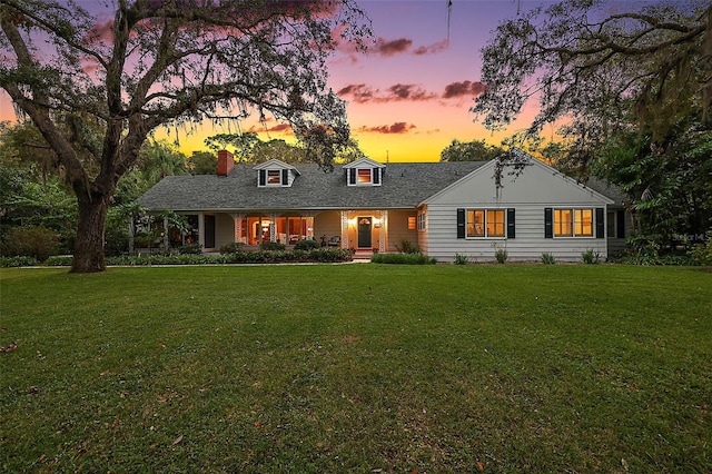 cape cod house with a lawn