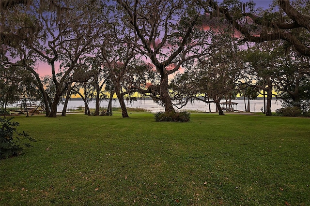 view of home's community with a lawn and a water view