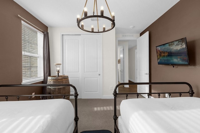 bedroom featuring carpet, a closet, and a notable chandelier