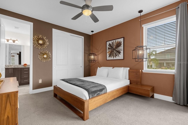 carpeted bedroom featuring connected bathroom, a closet, and ceiling fan