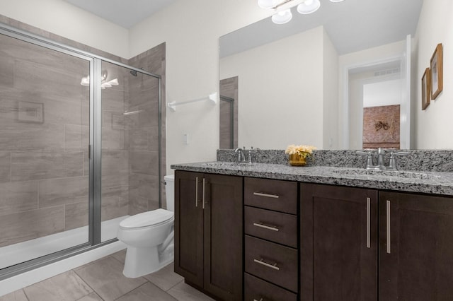 bathroom with vanity, a shower with shower door, and toilet