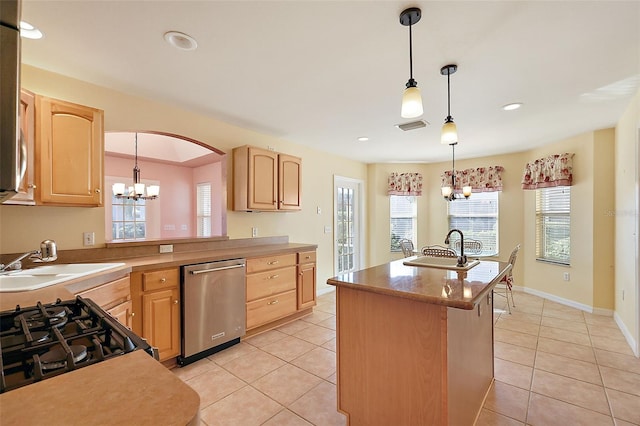 kitchen featuring light brown cabinets, sink, stainless steel dishwasher, decorative light fixtures, and a chandelier