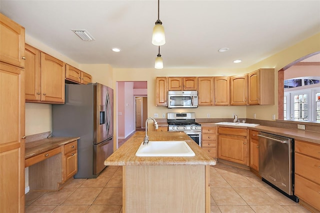 kitchen with pendant lighting, sink, an island with sink, and stainless steel appliances