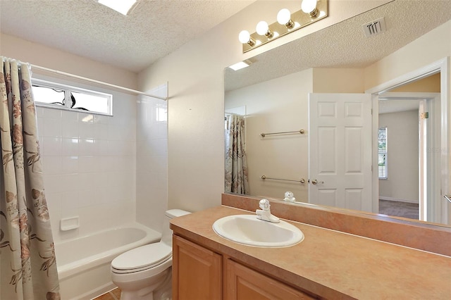 full bathroom featuring vanity, a healthy amount of sunlight, shower / bathtub combination with curtain, and a textured ceiling