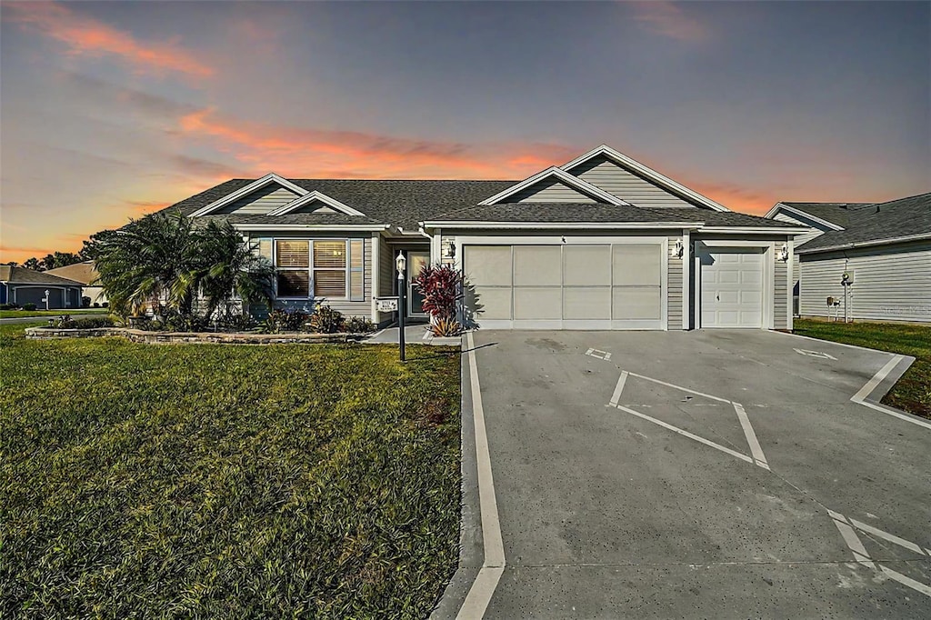 1711 Augustine Dr, The Villages, FL 32159 - ranch-style home featuring a garage, a front yard, driveway, and a shingled roof