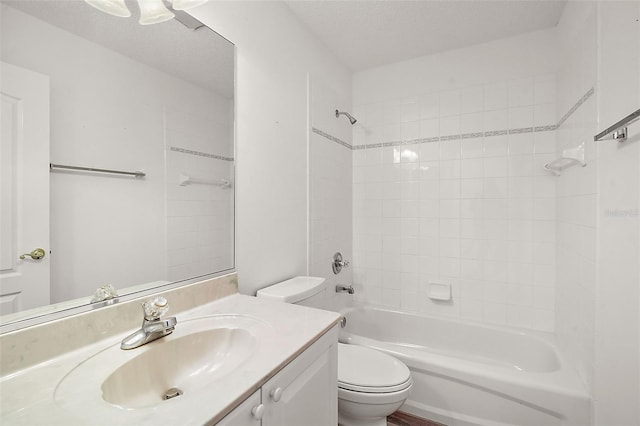 full bathroom featuring vanity, tiled shower / bath combo, a textured ceiling, and toilet