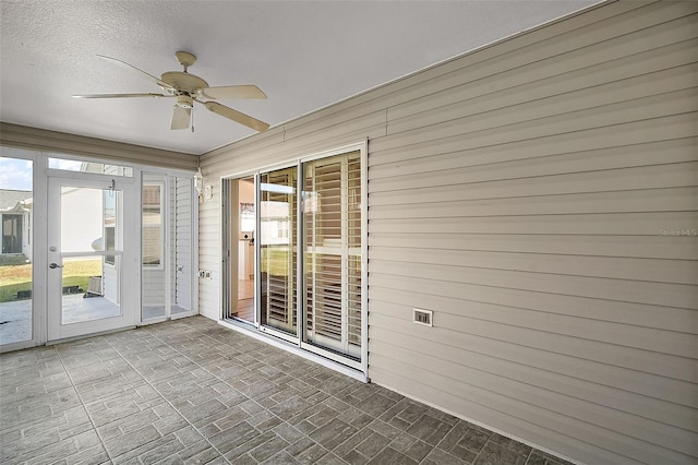 unfurnished sunroom with ceiling fan and a healthy amount of sunlight