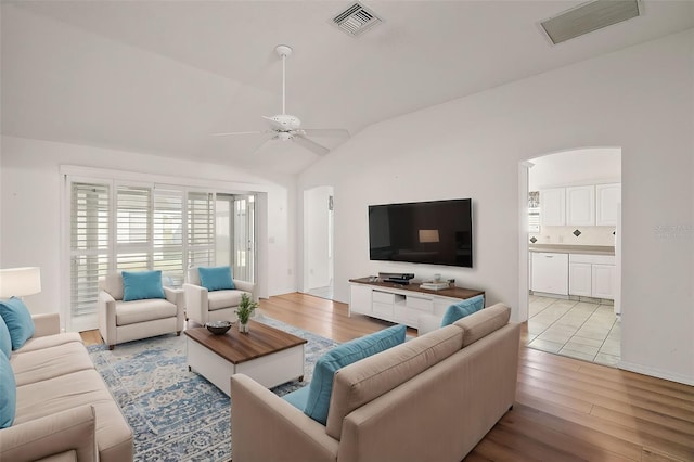 living room with light hardwood / wood-style floors, ceiling fan, and lofted ceiling