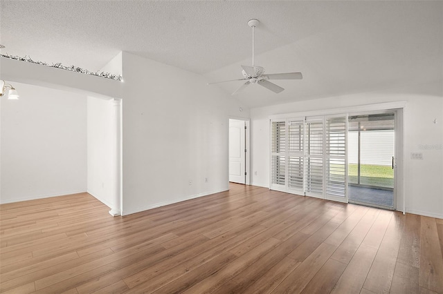 spare room featuring ceiling fan with notable chandelier, wood-type flooring, a textured ceiling, and lofted ceiling