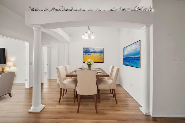 dining area with light wood-type flooring and an inviting chandelier