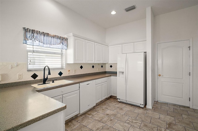 kitchen featuring decorative backsplash, white cabinetry, sink, and white appliances