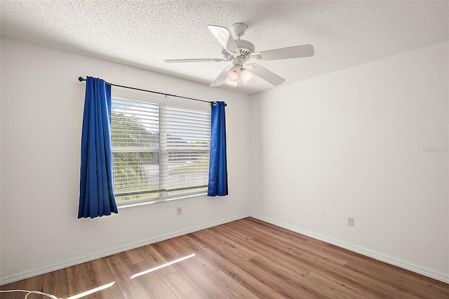 empty room featuring ceiling fan, a textured ceiling, and light wood-type flooring