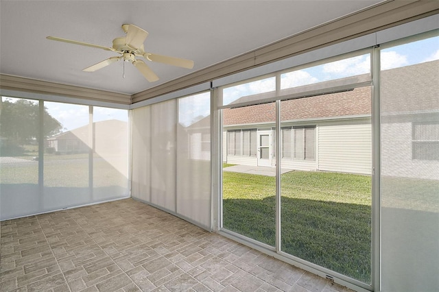 unfurnished sunroom featuring ceiling fan