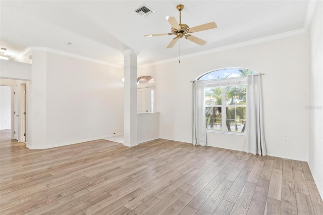 spare room featuring crown molding, ceiling fan, ornate columns, and light wood-type flooring