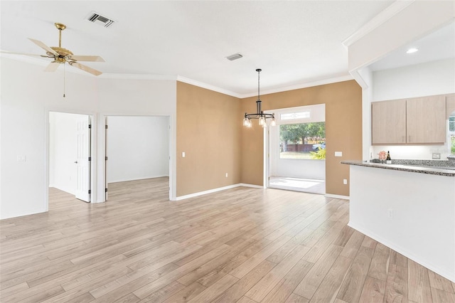 unfurnished living room featuring ornamental molding, ceiling fan with notable chandelier, and light hardwood / wood-style flooring