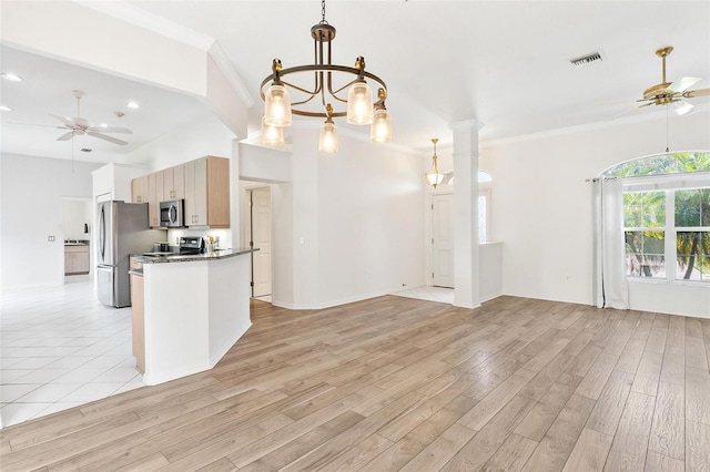 kitchen with ornamental molding, appliances with stainless steel finishes, ceiling fan with notable chandelier, and light hardwood / wood-style flooring