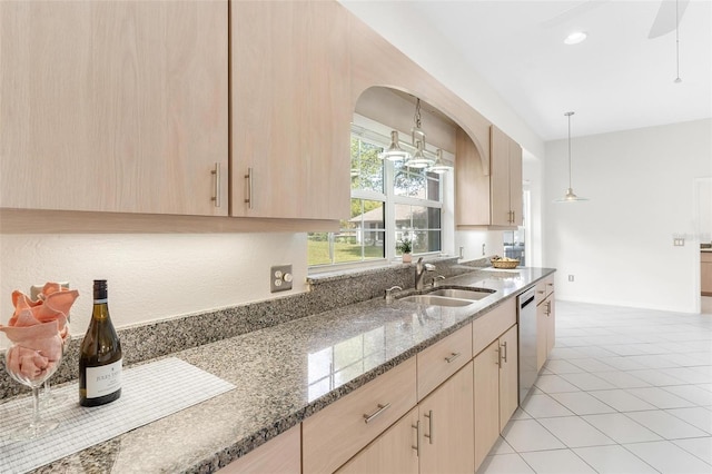 kitchen with hanging light fixtures, stainless steel dishwasher, sink, and light brown cabinets