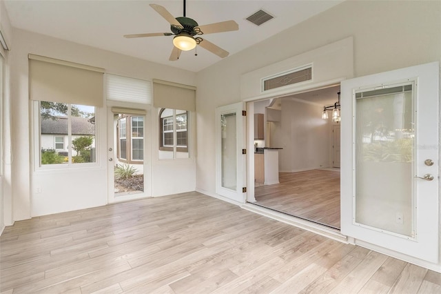 unfurnished sunroom with ceiling fan