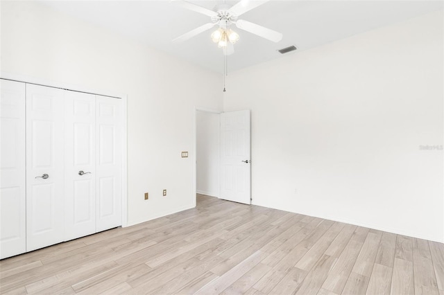 unfurnished bedroom featuring light hardwood / wood-style flooring, a closet, and ceiling fan