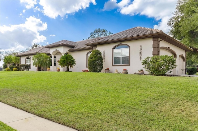 mediterranean / spanish house with a garage and a front lawn