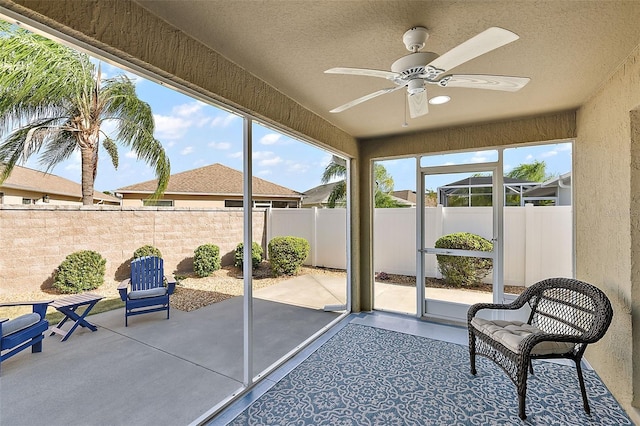 unfurnished sunroom with ceiling fan