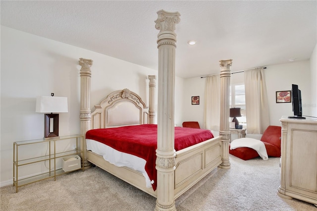 bedroom featuring light colored carpet and a textured ceiling