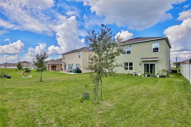 back of property featuring cooling unit and a yard