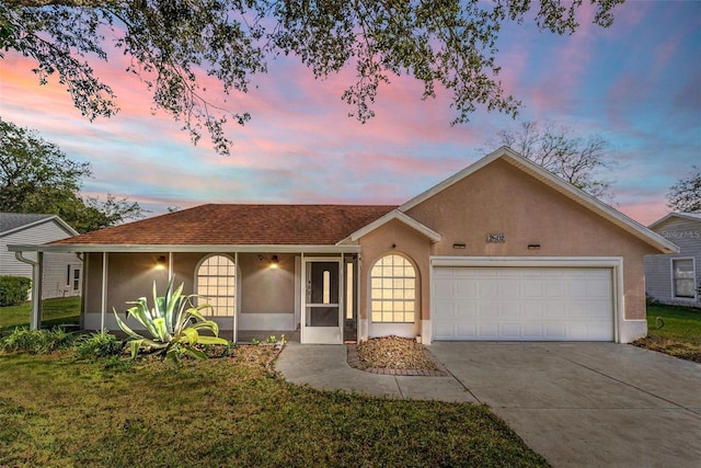 single story home with a garage and a yard