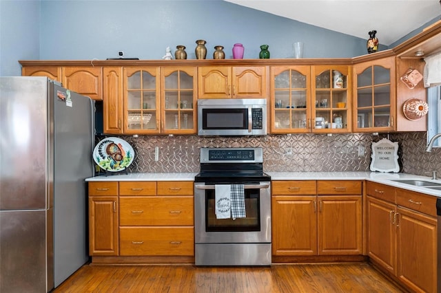 kitchen featuring backsplash, sink, stainless steel appliances, and lofted ceiling