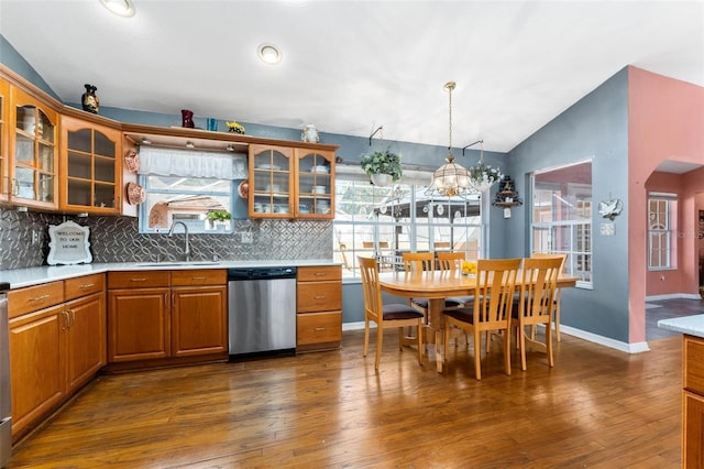 kitchen with vaulted ceiling, sink, pendant lighting, dishwasher, and dark hardwood / wood-style floors